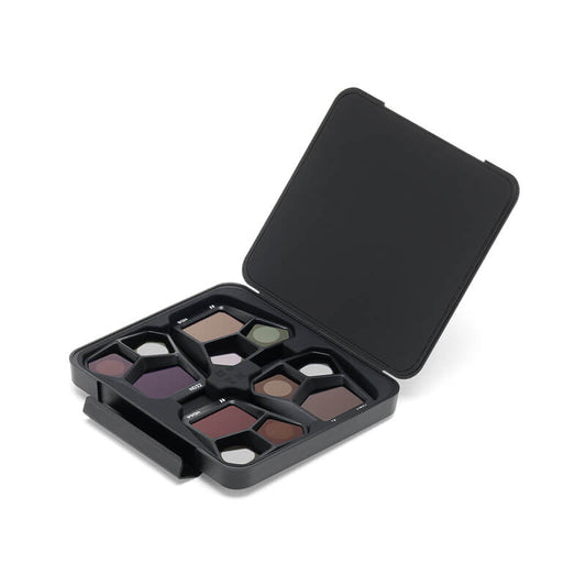 Makeup palette with various shades of eyeshadow in a black case on a white background