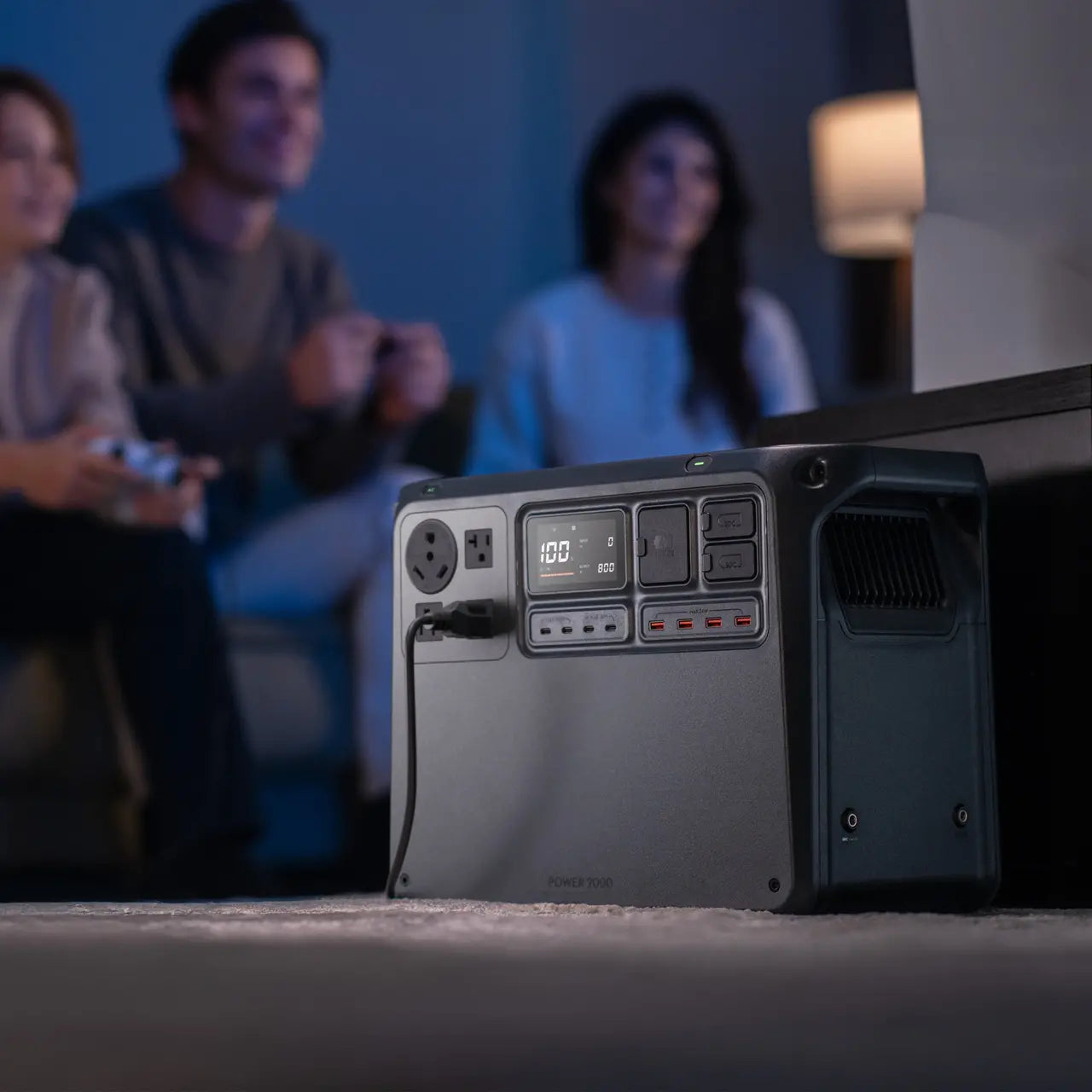 Portable power station on a table with people playing video games in the background