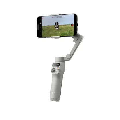 Handheld DJI Osmo Mobile 7 Smartphone Gimbal with smartphone displaying a dog on grass