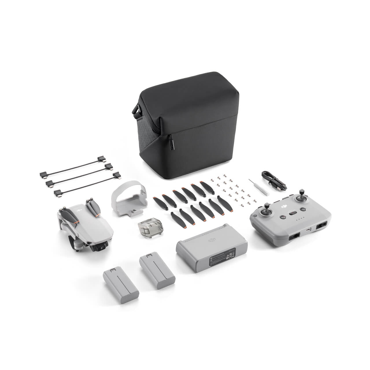 DJI Mini 2 SE drone components including body, propellers, remote control, and accessories on a white background