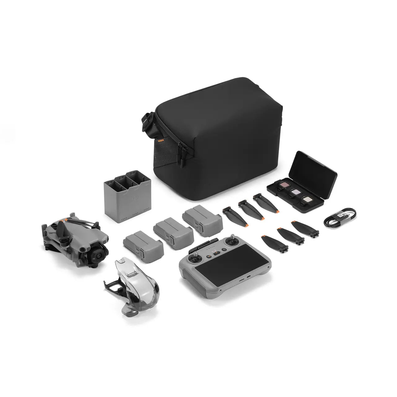 Collection of drone accessories including a black bag, remote control, and various parts on a white background.