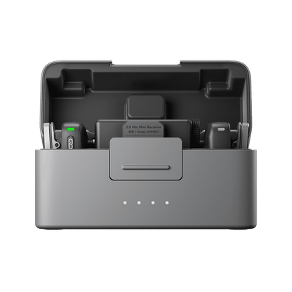 Gray DJI Mic Mini electronic device with components inside on a black background