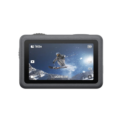 Action camera with screen displaying a skier in mid-air against a snowy mountain background.