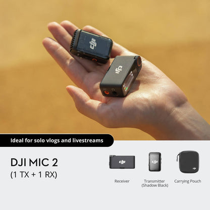 Hand holding DJI Mic 2 transmitter and receiver with carrying pouch on a yellow background