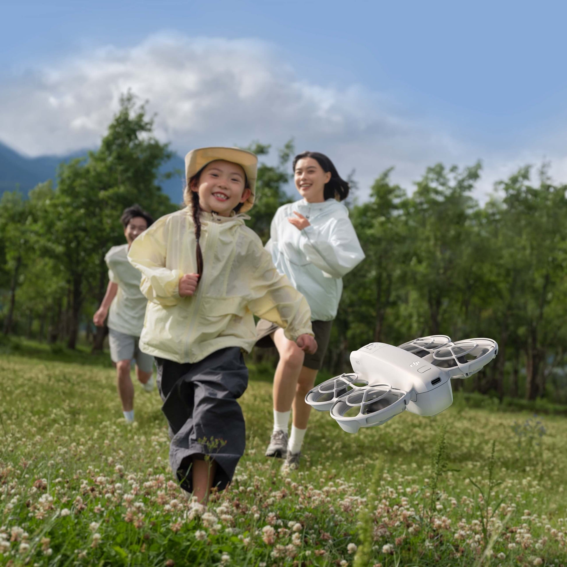 Children playing outdoors with a DJI Neo drone in a grassy field.